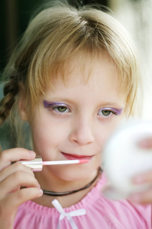 Child cosmetics. Little girl with lipstick.の写真素材
