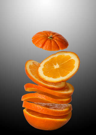 Flying orange. Sliced orange isolated on a black, white background. A frivolous fruit floating in...