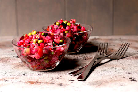 Still life. On a wooden table in a series of woody stalls stand translucent glass mice with ryko-red fruit salad, decorated with green leaves of pears. I have two metal forks. Culinary, diet, fasting.の写真素材
