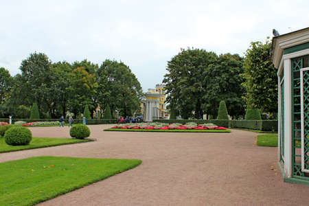 Walk through the square in a park with tall trees and a flat green lawn. Journey.の写真素材