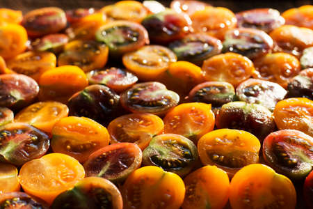 Bright yellow and red cherry tomatoes cut into pieces. Sunlight. Bokeh. Vegetarianism. Wallpaper.の写真素材