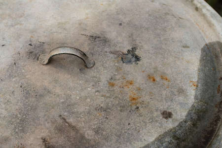Old zinc plated lid with a handle from the tank, rusty and scratched.の写真素材