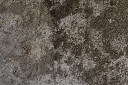 Black cracked concrete texture interspersed with small blue stones.の写真素材