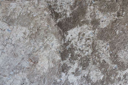 Black cracked concrete texture interspersed with small blue stones.の写真素材
