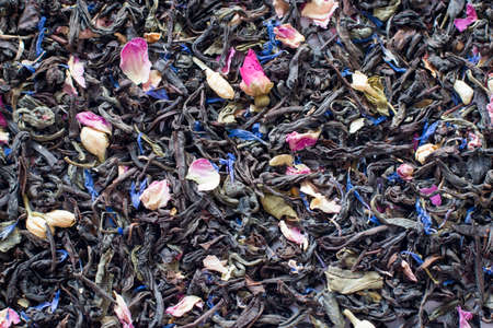 Mix tea with dried fruits and dried flowers. Tea background. Black tea with pink and blue petals. Health.の写真素材