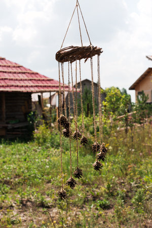Decoration and shamanic object made of pine cones and hemp rope on a ring of branches against a...