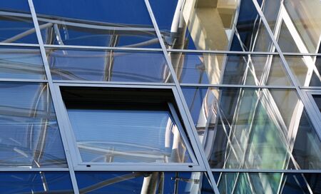 Modern building details in warm colors. Windows with reflection of lines and squares. Surface of...