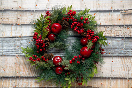 Christmas wreath of fir branches with apples and berriesの写真素材