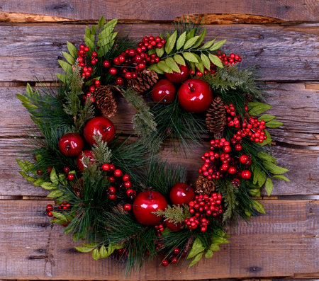 Christmas wreath of fir branches with apples and berriesの写真素材