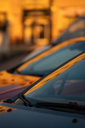 dawn vehicle gleam, sunrise over parked automobiles, morning light enhances resting car appearances, early sunlight illuminates motionless vehicles with radiant reflectionsの写真素材