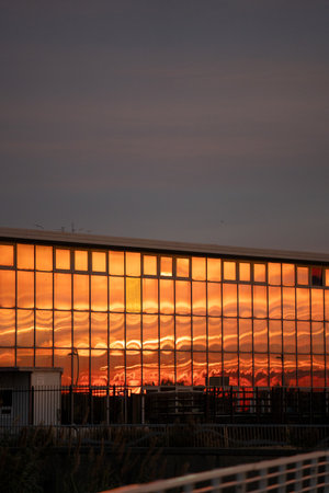 morning light bathes cityscape, sunrise casts warm hues over glass and rooftops scene, predawn to sunrise time capturing serene reflections and tranquil city atmosphereの写真素材