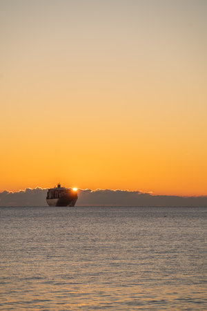Morning sun aligns with ship creating vivid backlit scene with contrast, Early morning sunlight...
