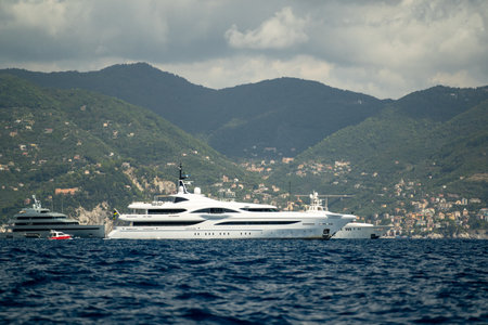 luxury yacht scenery, refined superyacht resting in tranquil bay among hillside villas and mountain...