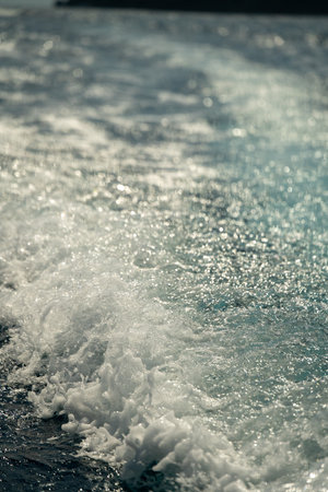 gentle waves and bright reflections, calm sea with shimmering wake and tranquil holiday ambiance