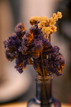 cozy seasonal bouquet in vintage container, warmtoned dried flowers arranged in rustic glass vessel