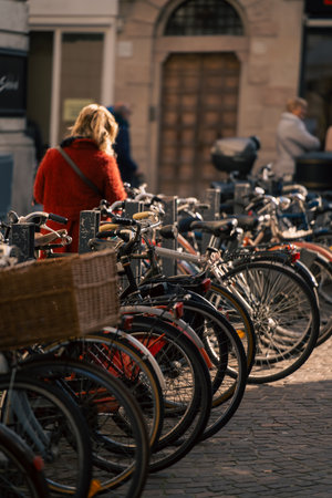 redcoated woman studies map on street, urban woman in vibrant coat inspects map amidst cobblestonesの写真素材