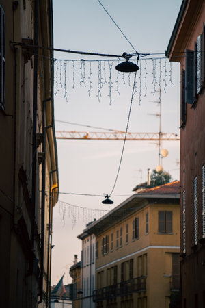charming street with festive lights, street scene featuring vintage lamps and colorful facades at...