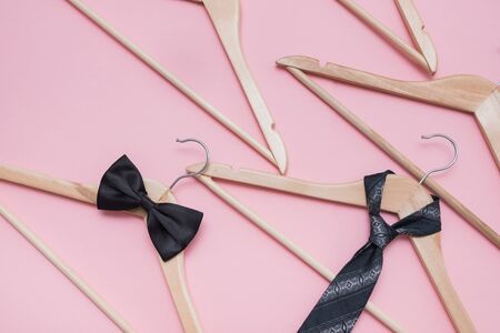 bow tie on a hanger and empty wooden hangers on a pink background. Concept: sale of men's accessoriesの写真素材