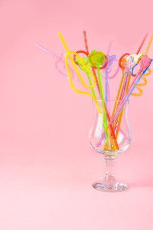 multicolored plastic cocktail straws in a glass tumblerの写真素材
