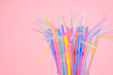 multicolored plastic cocktail straws in a glass tumblerの写真素材