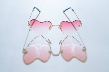 pink heart-shaped sunglasses cast a pink heart-shaped shadowの写真素材