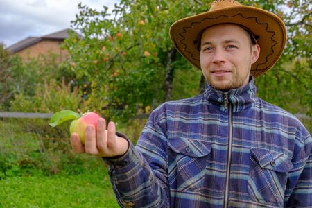 male farmer holds a ripe red appleの写真素材