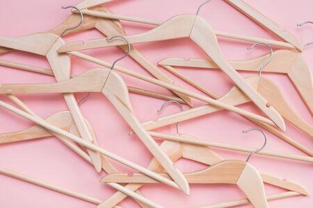 wooden empty clothes hangers on a pink backgroundの写真素材