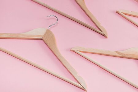 wooden empty clothes hangers on a pink backgroundの写真素材