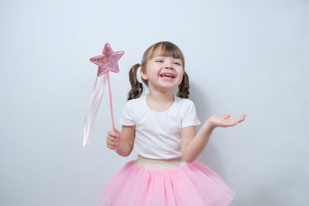 smiling little girl child holding a magic wand in his handの写真素材
