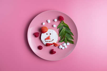 Childrens breakfast or lunch, snowman toast with raspberries, strawberries, curd cheese, marshmello and Christmas mint spruce. New Years table decoration.の写真素材