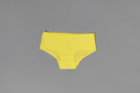 Yellow cotton female panties on gray backgroundの写真素材