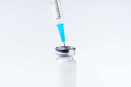 Close up glass vial with flu vaccine and syringe with needle. The concept of vaccination or preventive treatment of injection diseases.の写真素材
