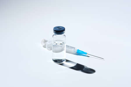 Close up glass vial with flu vaccine and syringe with needle. The concept of vaccination or preventive treatment of injection diseases.の写真素材