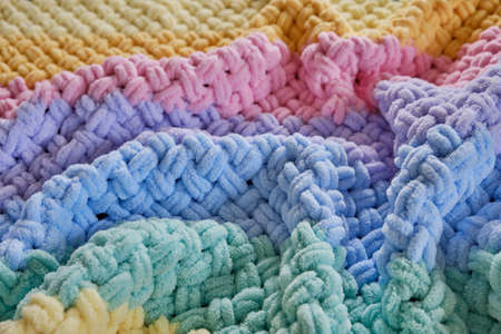 The texture is a warm bright plaid made of multicolored terry loop yarn. Thread loops pattern. A cozy pastime for a hobbyの写真素材