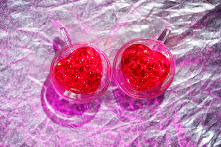 Image for valentines day. Two glass mugs in the shape of hearts in bright light.の写真素材