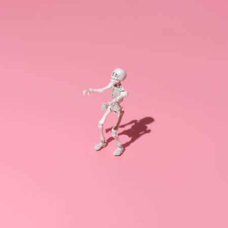 a human skeleton strides like a zombie with outstretched arms. Trending image on a pink background for the holiday Halloweenの写真素材