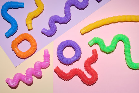 Multi-colored corrugated plastic pipes on a bright background. Popular poptube game in the form of simple shapes and winding lines on a colorful backgroundの写真素材