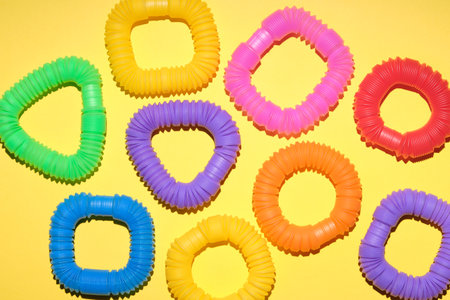 Multi-colored corrugated plastic pipes on a bright background. Popular poptube game. Simple...