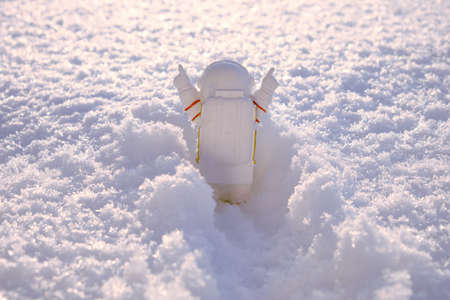 figurine of an astronaut making his way through a snowdrift with his hands upの写真素材