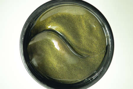 Hydrogel patches for the skin around the eyes with gold sparkles. Modern skin care products. Anti-aging treatment for dark circles and wrinklesの写真素材