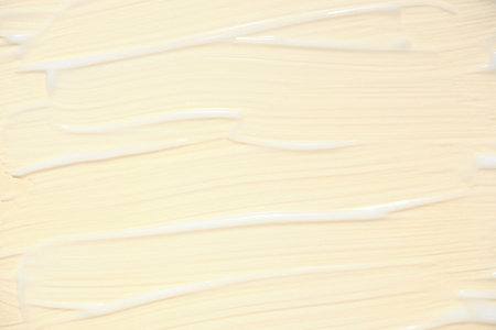The texture of a facial skin care product on a beige background. Smears of white cream with shimmer effect. Anti-aging anti-wrinkle careの写真素材