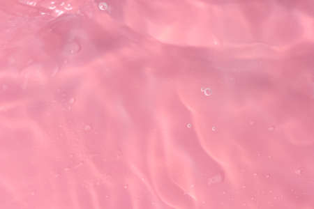 Abstract background. The texture of the waves on a pink background. Bubbling water, splashes and drops.の写真素材