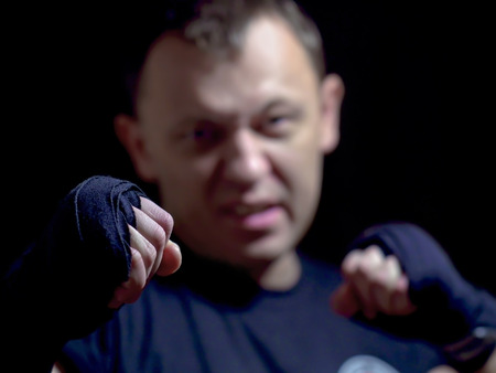 Fist of an aggressive young male, close-up, blurred background