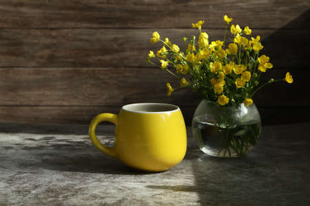 yellow cup of coffe with yellow flowersの写真素材