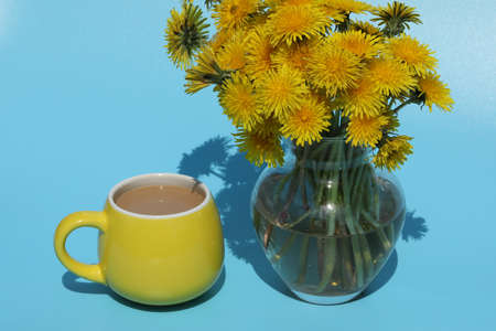cup of coffee with dandelion bouquetの写真素材