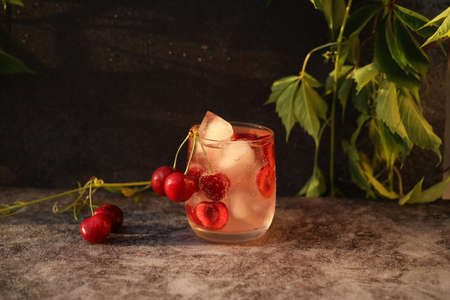 Glass of cold drink with sweet cherryの写真素材