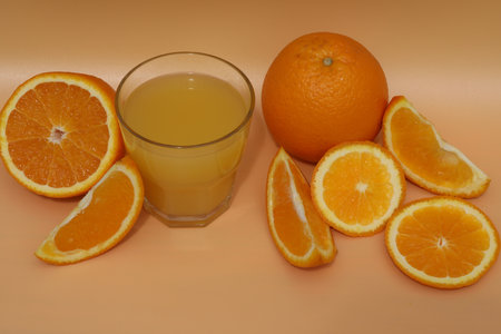 fresh bright orange juice with oranges on yellow backgroundの写真素材
