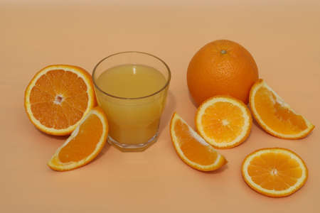 fresh bright orange juice with oranges on yellow backgroundの写真素材