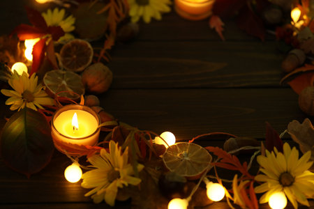 dark rustic wooden background with candles, autumn leaves and copy spaceの写真素材