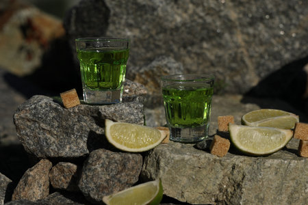 green absinthe drink on the rockbackground with sugar and limeの写真素材